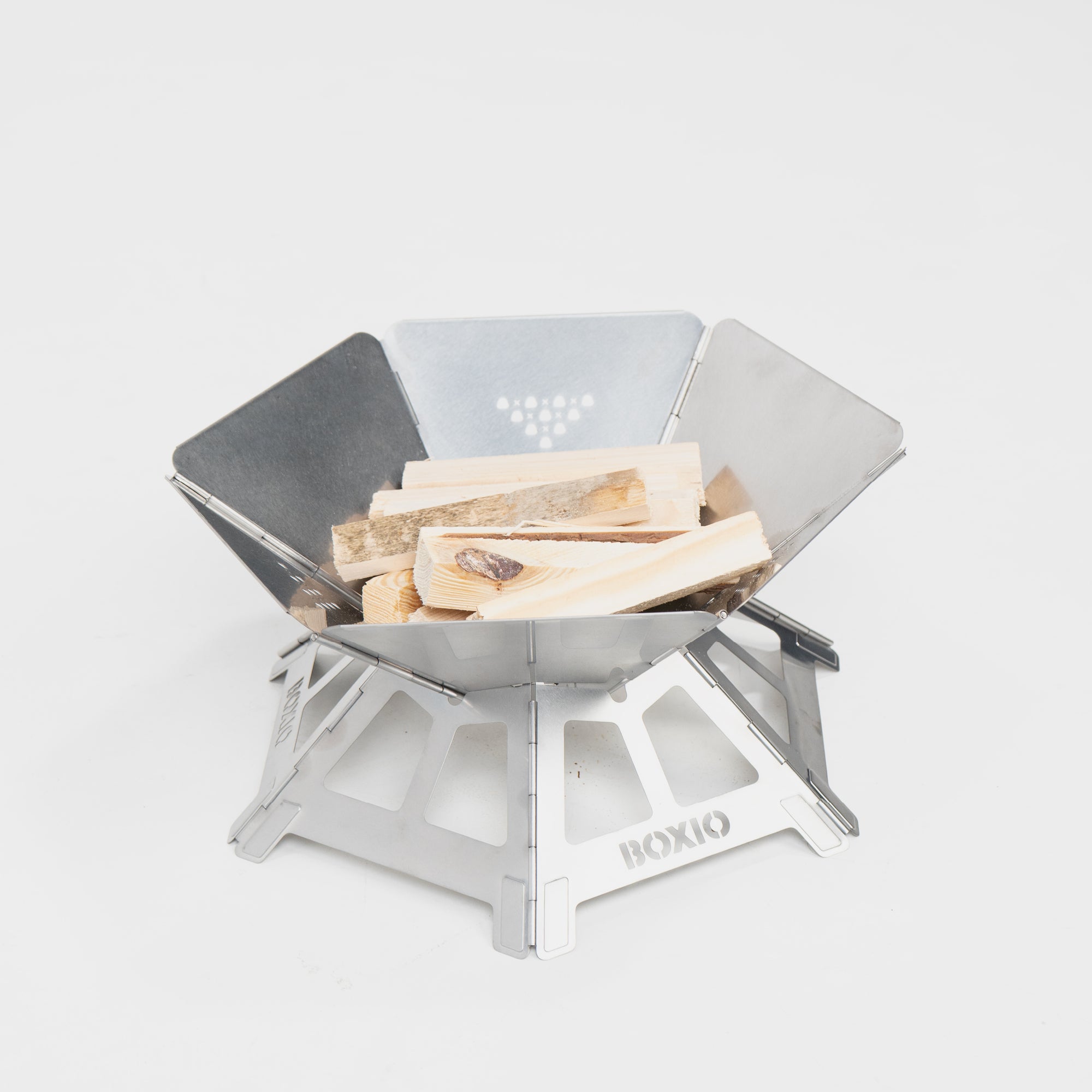 Kompakter, tragbarer Campingofen aus Edelstahl mit Holzstücken für ein Feuer.